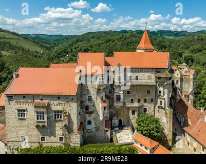 Vue aérienne du château de Pernstejn avec le toit rouge du palais gothique, tours rectangulaires et rondes, barbican, plate-forme de canon avant en Moravie Banque D'Images