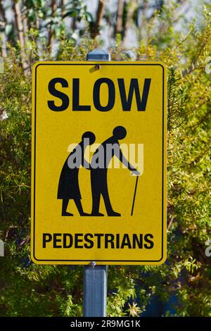 Attention ralentissez les piétons signe sur le poteau avec fond jaune, Maldon, Victoria, Australie. Banque D'Images