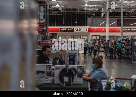 Une image dynamique capture une scène animée dans un espace culinaire Costco. Les clients attendent patiemment, anticipant avec impatience leur tour pour essayer les nouveaux sushis. L'excitation dans l'air est palpable lorsque les gens se rassemblent autour du comptoir de nourriture. Costco, le célèbre détaillant en gros, a pris une mesure audacieuse en ajoutant des sushis à son menu de restauration abordable. L'introduction de cette nouvelle cuisine s'est traduite par de longues files d'attente et des temps d'attente accrus, car les membres pressés se précipitent pour goûter la dernière offre de Costco.les clients n'ont pas perdu de temps à partager leurs opinions en ligne, ce qui a donné lieu à une véritable frénésie Banque D'Images