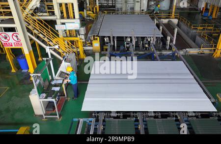 HAI'AN, CHINE - 28 JUIN 2023 - les travailleurs traitent des cadres en alliage d'aluminium pour les centrales photovoltaïques dans un atelier à Hai 'an, province de Jiangsu, Chine, Banque D'Images