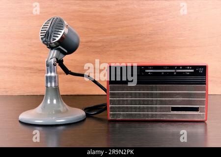 Radio rouge vintage et microphone rétro sur table en bois. Effet vintage Banque D'Images