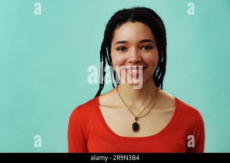 Jeune femme adulte avec des cheveux braïdes regardant l'appareil photo, prise de vue en studio Banque D'Images