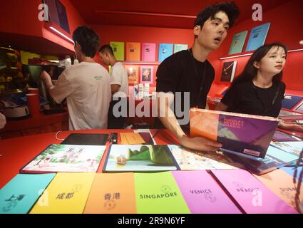 SHANGHAI, CHINE - 28 JUIN 2023 - le personnel des ventes fait la queue des sacs et des livres en toile avec le LOGO de la marque Louis Vuitton à l'entrée d'un café Louis Vuitton Banque D'Images