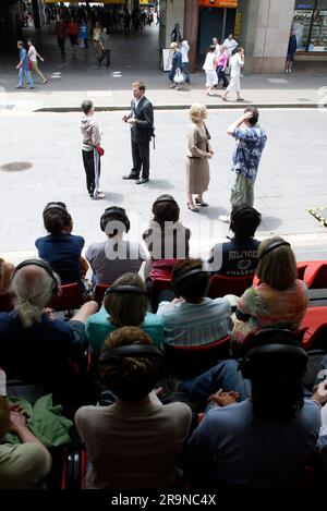 Les acteurs Allan V. Watt, Simon Laherty, Jim Russell et Geneviève Morris dans l’événement de théâtre de rue « Small Metal Objects », où quatre acteurs sont micros tandis que le public écoute avec des écouteurs le dialogue lorsqu’il se joue dans une rue animée de la ville. Festival de Sydney, Circular Quay, Sydney, Australie . 08.01.07. Banque D'Images