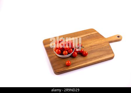 Tomates cerises fraîches rouges sur planches à découper et dans un bol en withe Banque D'Images