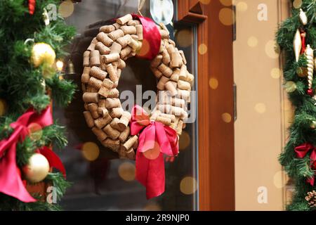 Belle couronne de Noël faite de bouchons de vin accrochés à la porte en verre Banque D'Images