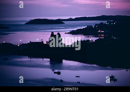 Scalloway, Mainland, îles Shetland, Écosse vers 1995. Le château en ruines de Scalloway au crépuscule, le port et les petits bateaux de pêche en profil. ROYAUME-UNI 1970S HOMER SYKES Banque D'Images