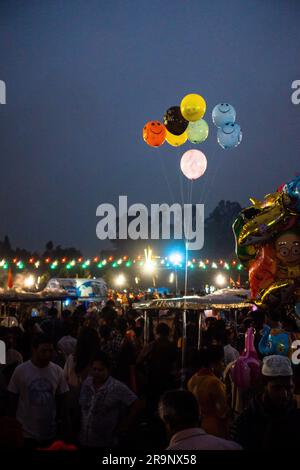 19 octobre 2022, Dehradun, Uttarakhand, Inde. Photo nocturne d'une foire avec des éclairs et des ballons dans l'air avec des gens tout autour. Banque D'Images