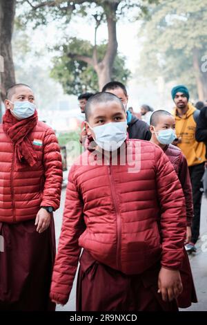 Un groupe de personnes portant des masques de visage marchant le long d'une rue animée, New Delhi, Inde Banque D'Images