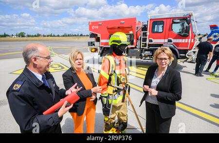 28 juin 2023, Basse-Saxe, Brunswick : Dieter Rohrberg (l-r), directeur des pompiers de Basse-Saxe, Nancy Faeser (SPD), ministre fédéral de l'intérieur, et Daniela Behrens (SPD), ministre de l'intérieur de Basse-Saxe, se tiennent à côté d'un mannequin avec des vêtements de protection et d'un véhicule de lutte contre les incendies utilisé par le service des incendies pour combattre les incendies de forêt à l'aéroport de Braunschweig-Wolfsburg. Le ministère de l'intérieur de Basse-Saxe a présenté le portefeuille complet de la Basse-Saxe pour la lutte contre les incendies de végétation à l'aéroport - y compris le nouvel avion de lutte contre les incendies, qui sera utilisé en particulier pour les feux de forêt. Photo : Banque D'Images