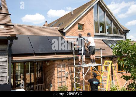 Deux techniciens installant des panneaux Perlite noirs de 410kW sur un toit en tuiles à Colemans Hill Farm Mickleton, Royaume-Uni Banque D'Images