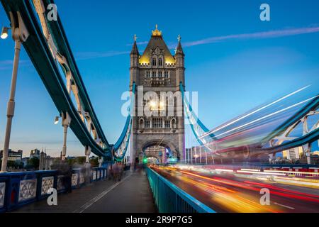 Les voitures et les bus passent des rayons sur le Tower Bridge la nuit à Londres, au Royaume-Uni Banque D'Images