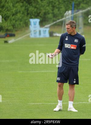 28 juin 2023, Basse-Saxe, Osnabrück: Football: 2nd division, VfL Osnabrück, lancement de l'entraînement au terrain d'entraînement d'Illoshöhe. L'entraîneur Osnabrück Tobias Schweinsteiger commande à distance l'arrosage de l'herbe. Photo: Friso Gentsch/dpa Banque D'Images