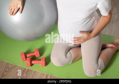 Une fille enceinte entre pour le sport dans le 3rd trimestre de la grossesse. Fitness et Pilates. La santé des femmes. Banque D'Images