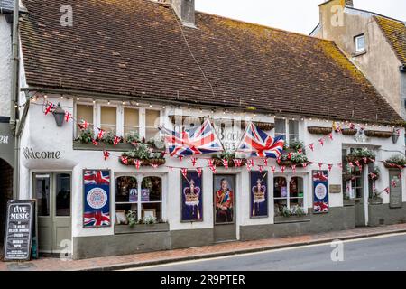 Le pub Olde Black Horse affiche des drapeaux et des portraits du roi à l'extérieur du pub pour célébrer le couronnement, Rottingdean, Sussex, Royaume-Uni. Banque D'Images