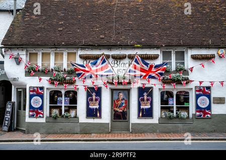 Le pub Olde Black Horse affiche des drapeaux et des portraits du roi à l'extérieur du pub pour célébrer le couronnement, Rottingdean, Sussex, Royaume-Uni. Banque D'Images