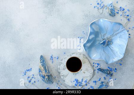 Composition avec plaques d'art en résine, tasse à café et pierres bleues sur fond gris. Pose à plat Banque D'Images