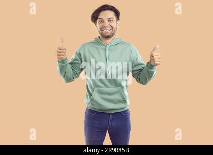 Beau jeune homme montrant les pouces vers le haut sourire heureux Banque D'Images