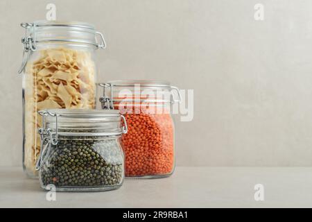 Haricots mungs crus, lentilles rouges et pâtes dans des pots en verre. Concept de stockage des déchets zéro. Banque D'Images