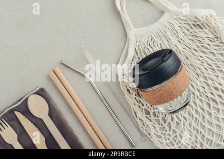 Kit zéro déchet. Ensemble de couverts écologiques en bambou, sac en coton, gobelet à café réutilisable, pailles à boire en bambou et en métal et bouteille en verre. Banque D'Images