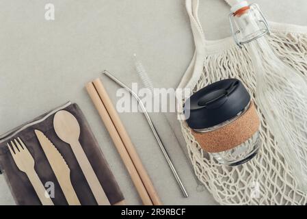 Kit zéro déchet. Ensemble de couverts écologiques en bambou, sac en coton, gobelet à café réutilisable, pailles à boire en bambou et en métal et bouteille en verre. Banque D'Images