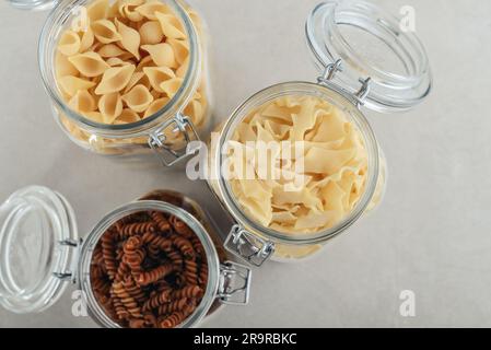 Trois différents types de pâtes dans des pots en verre, vue du dessus. Concept de stockage des déchets zéro. Banque D'Images