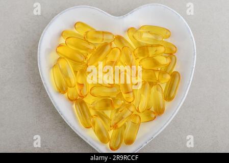 Vue de dessus des capsules d'huile de poisson omega-3 sur l'assiette sur la table en béton Banque D'Images