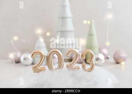 Sapin en céramique décoratif avec boules de noël et bougies dorées en forme de numéro 2023 Banque D'Images