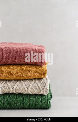 Pile de vêtements d'hiver tricotés à la main sur fond clair : chandails, tricots, espace pour le texte Banque D'Images