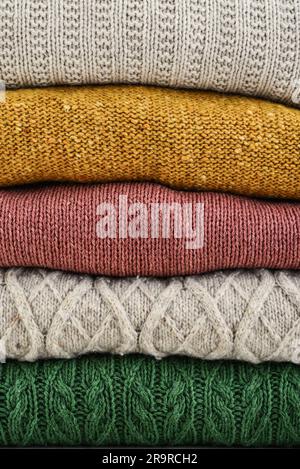 Pile de vêtements d'hiver tricotés à la main comme arrière-plan : pulls, tricots Banque D'Images