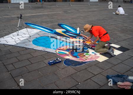 Kaiserslautern, Allemagne. 28th juin 2023. Maureen Kolhoff travaille avec plusieurs tasses de peinture sur sa peinture colorée. Onze artistes internationaux de 6 pays transforment le pavé Stiftsplatz (place) en art tridimensionnel. 3D l'art de la rue utilise la perspective pour créer l'illusion optique de l'espace. Les visiteurs sont invités à observer tous les artistes au travail pendant trois jours, du mercredi à 8 h 00 au vendredi à 6 h 00. Cette année, le sujet est « Digitalisation et Smart City ». Les tableaux illustrent des robots, des données ou des scénarios de cyberpunk. Credit: Gustav Zygmund/Alamy News Banque D'Images