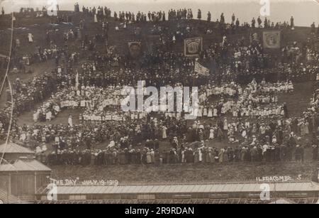 Journée de la paix d'Ilfracombe, 19 juillet 1919 : une foule importante marquant la Journée, une journée de célébration et de commémoration qui a marqué la fin officielle de la première Guerre mondiale après la signature du Traité de Versailles le 28 juin 1919. La photo montre un grand groupe d'enfants qui épelent le mot « PAIX » alors que (la plupart du temps) est vêtu de blanc et debout sur une colline. Des drapeaux et des bannières de style syndical sont également exposés, Banque D'Images