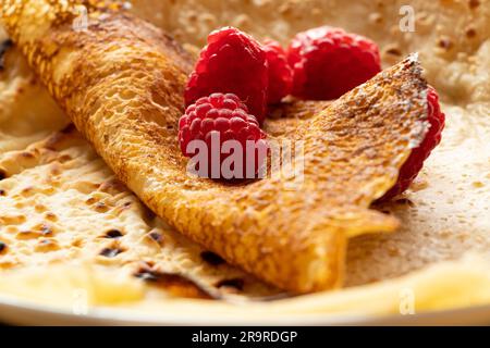 Crêpes fines avec framboises en gros plan, dessert et petit déjeuner Banque D'Images