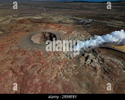 Vue aérienne d'un évent sulfurique en Islande, avec de la vapeur qui s'élève de l'évent et un volcan dormant en arrière-plan Banque D'Images