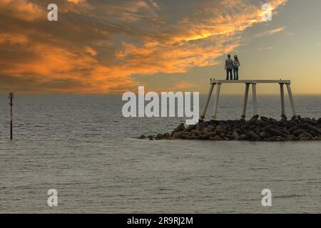 Newbiggin-on-Sea, Angleterre du Nord-est, Royaume-Uni - 26 juin 2023 - Statue d'un couple qui regarde la mer tandis que le soleil se couche Banque D'Images