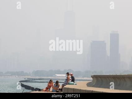 Chicago, États-Unis. 28th juin 2023. Les gens s'assoient près du lac Michigan tandis qu'une brume fumée entoure le centre-ville de Chicago, Illinois, mercredi, 28 juin 2003. La fumée des feux de forêt canadiens s'est glissée dans le Midwest supérieur des États-Unis, ce qui a donné lieu à des avertissements sur la qualité de l'air. Photo de Tannen Maury/UPI crédit: UPI/Alay Live News Banque D'Images