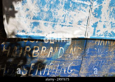 Publicité écrite à la main peinte sur le côté de hutte bleue, tressage de cheveux et équitation, Natadola Beach, Fidji. Banque D'Images