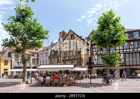 Colmar, France - 21 juin 2023: Place dominicaine à Colmar, France avec des maisons à colombages et des touristes, en appréciant s'asseoir dans les cafés en été Banque D'Images