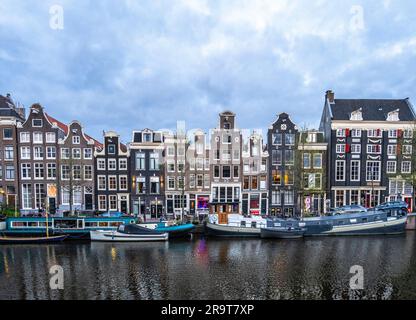 Maisons sur le canal Singel ainsi que des bateaux à moteur à Amsterdam Banque D'Images