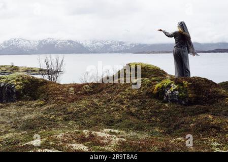 Femme païenne nordique faisant une offrande à la mer. Banque D'Images