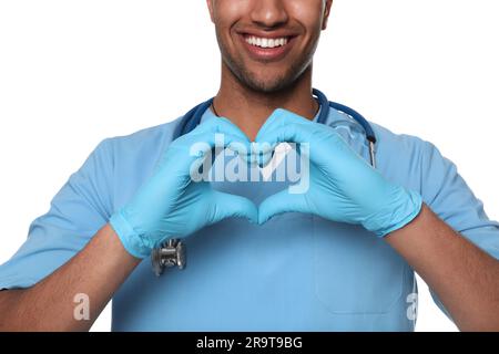 Médecin ou assistant médical (infirmière masculine) en uniforme faisant la forme du coeur avec les mains sur fond blanc, gros plan Banque D'Images