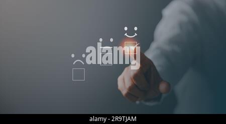Service à la clientèle et concept de satisfaction, le Business Person touche l'écran virtuel sur l'icône Happy Smiley face pour donner satisfaction dans le service. Banque D'Images
