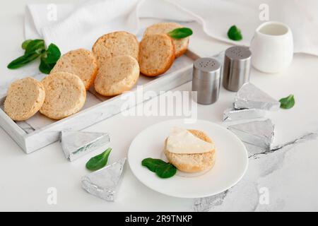 Assiettes avec des croûtons et des triangles de savoureux fromage fondu sur fond de marbre blanc Banque D'Images