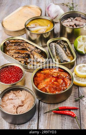 Variété de boîtes ouvertes avec différents types de poissons en conserve et de fruits de mer Banque D'Images