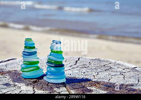 deux pyramides équilibrées de bouteille de verre poli de mer s'écaent sur une surface en bois abîmée sur la toile de fond de la mer. méditation par l'océan Banque D'Images