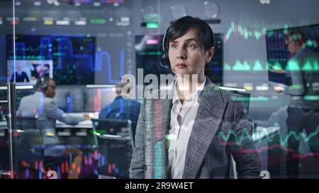 Femme négociatrice, femme d'affaires travaille dans le bureau d'agence de courtier. 3D résumé l'animation de l'IA des stocks en temps réel et des cartes de crypto-monnaie sur un mur de verre. Ordinateurs et grands écrans numériques en arrière-plan. Banque D'Images