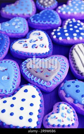 Tas de coeur bleu violet en forme de coeur avec de beaux biscuits glaçés royaux à motifs Banque D'Images