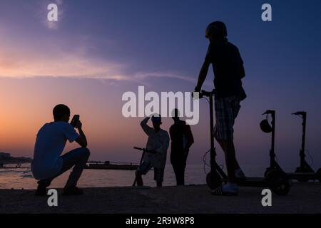 Un groupe de jeunes hommes sur la plage de Sousse au coucher du soleil, Tunisie Banque D'Images