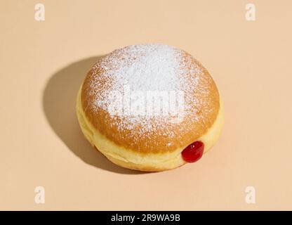 beignet de gelée fraîchement cuit sur fond beige Banque D'Images
