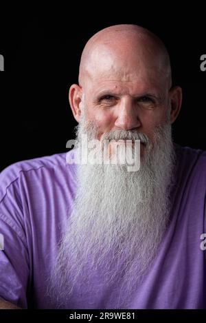 Portrait d'un homme avec une longue barbe grise portant un t-shirt violet gros plan Banque D'Images